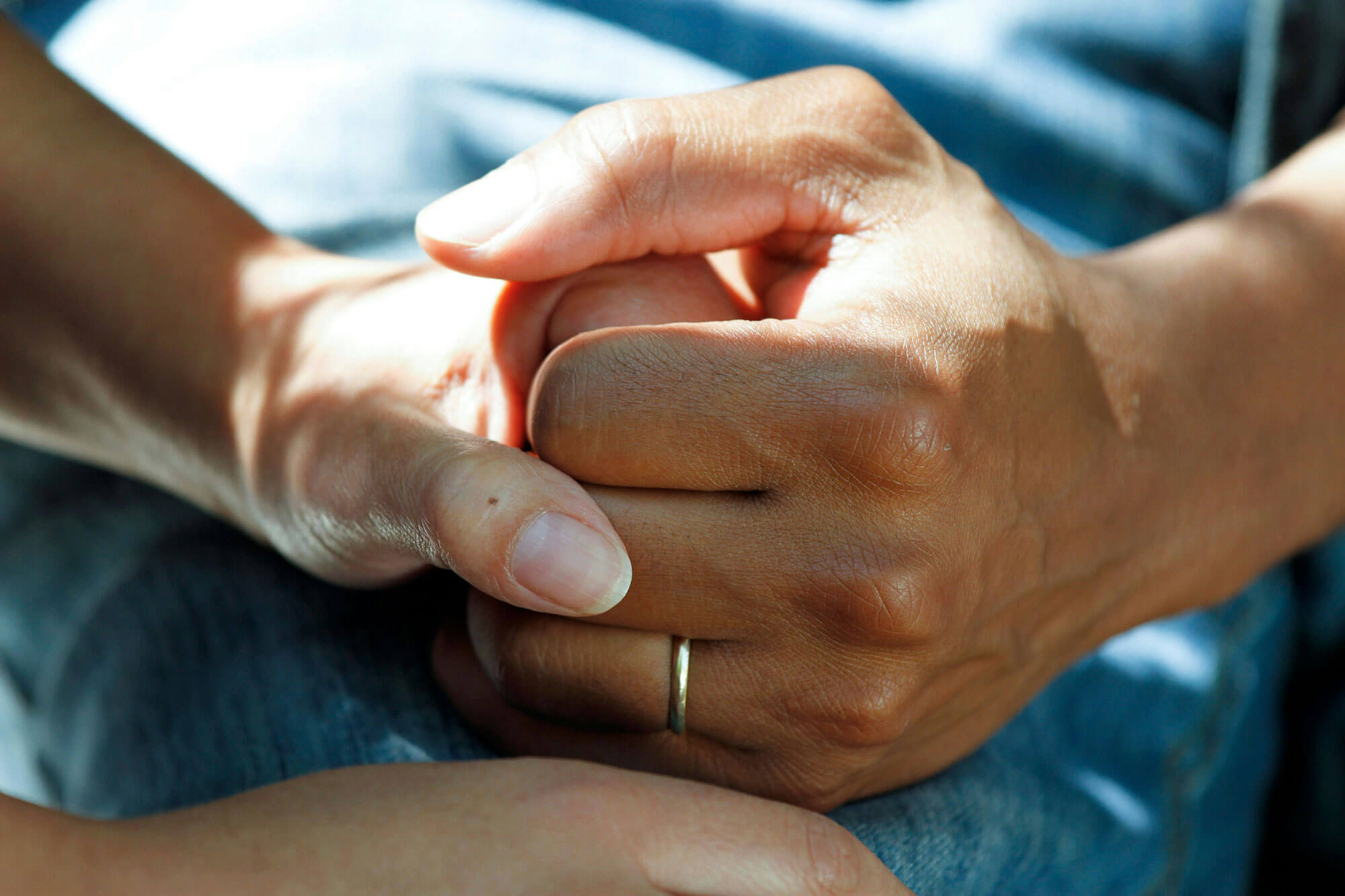 Caregiver holding the hands of a patient