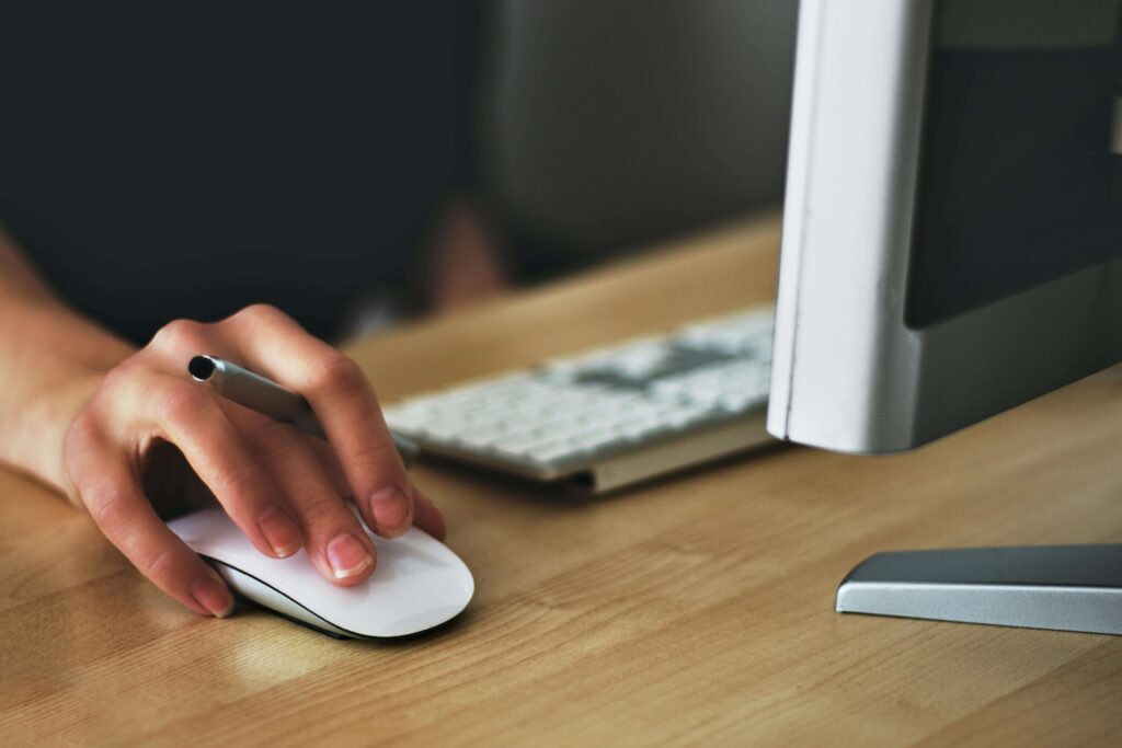 Hand using a mouse at a computer.