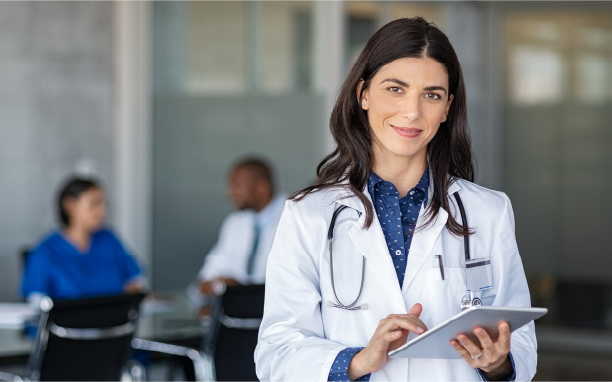 A woman doctor with a tablet, smiling.